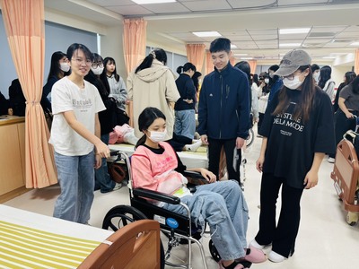 穿戴好體驗服同學互相推輪椅圖片