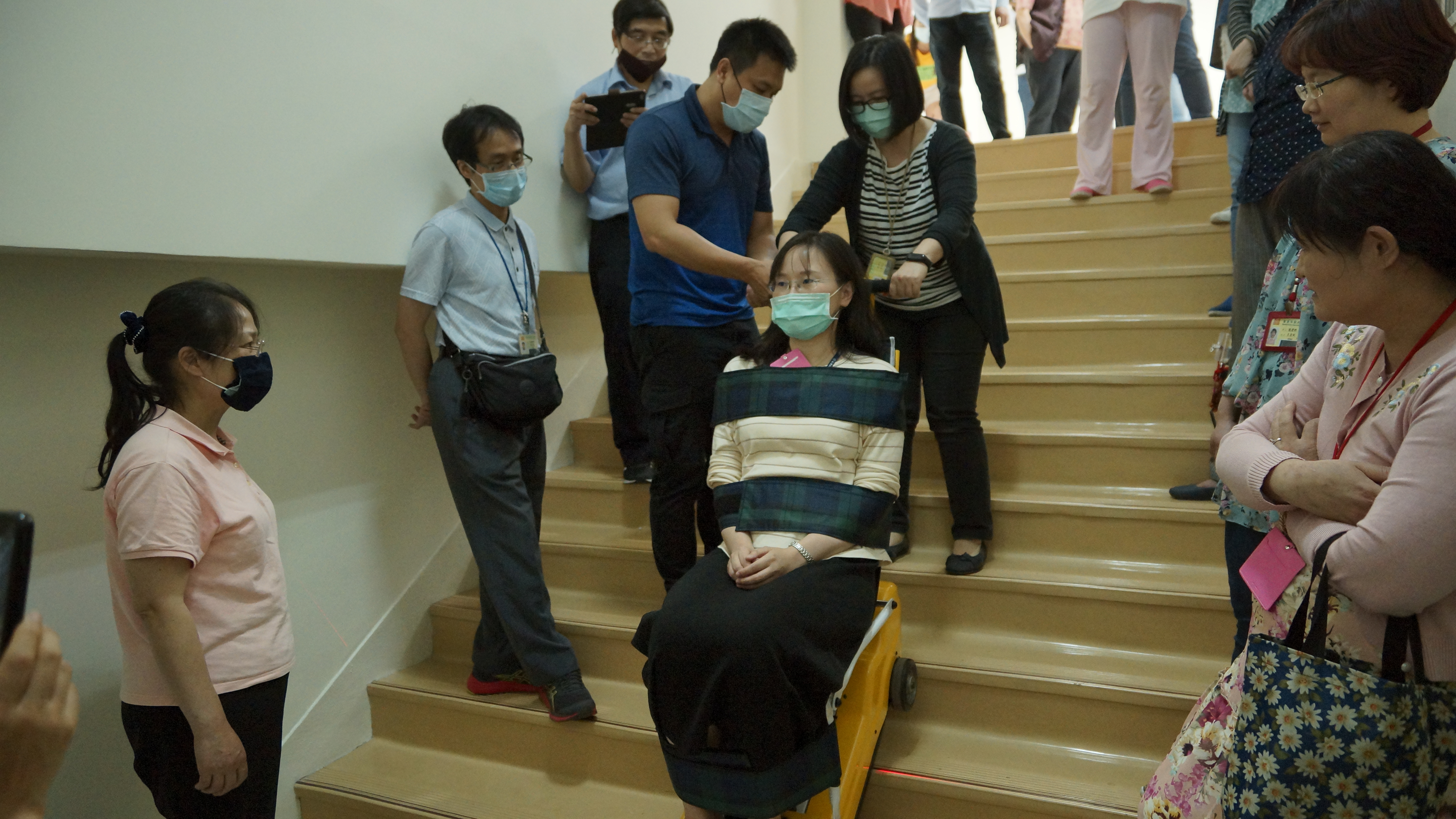 教師們在廠商解說人員協助下體驗、操作爬梯機